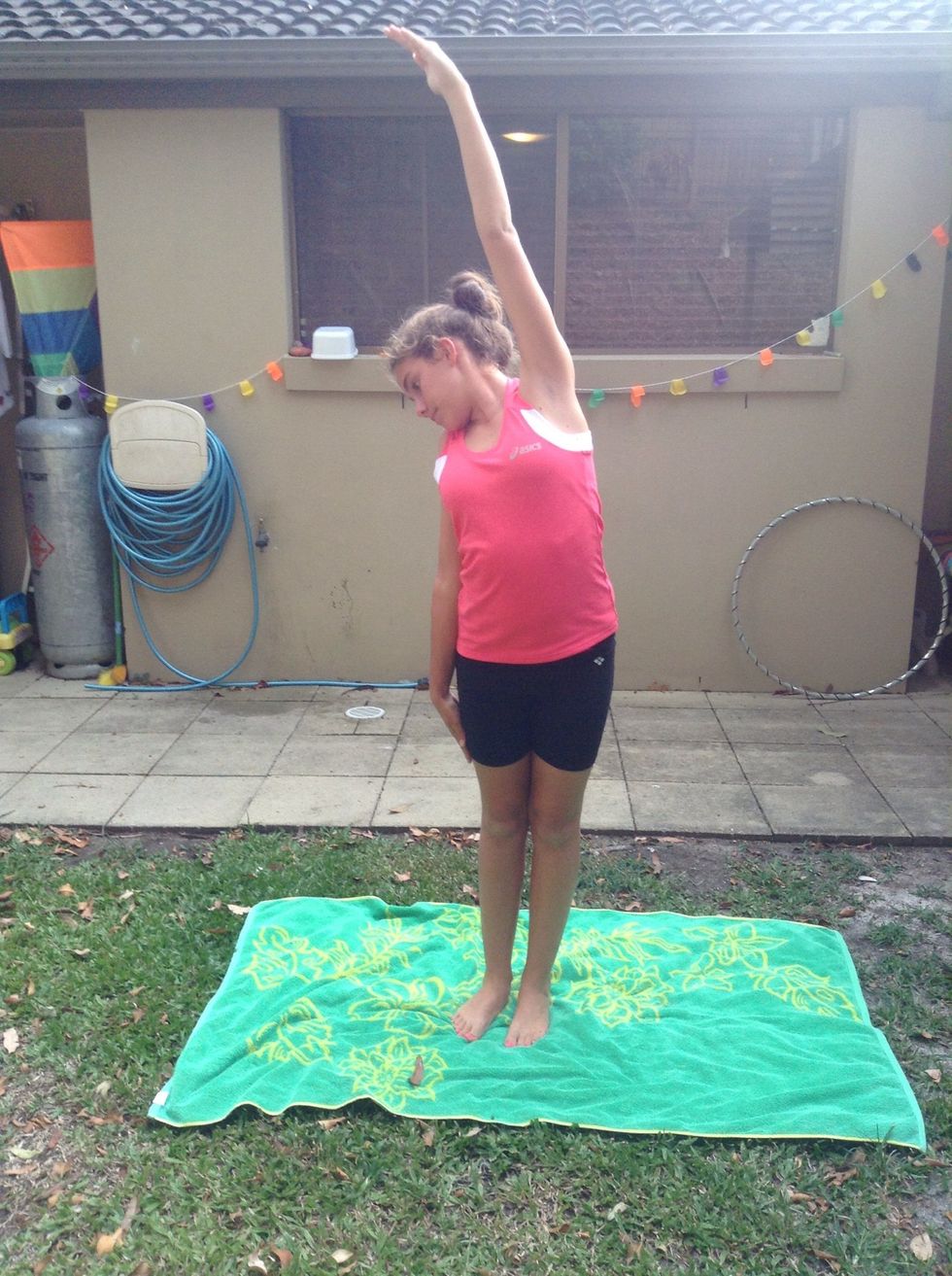 Stand on two feet . Put one arm in the air and the other arm by your side. And hold for 15 seconds