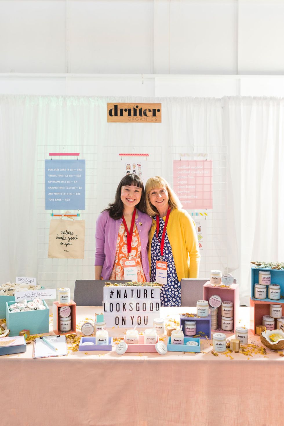 Stand out from your competitors by making sure to style these out with fun props and risers! These ladies used glossy color boxes to feature their product and added a cute message board sign.
