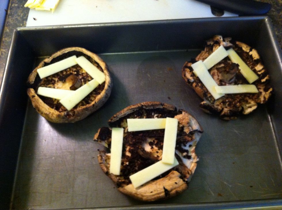 Start adding cheese to the portobellos.