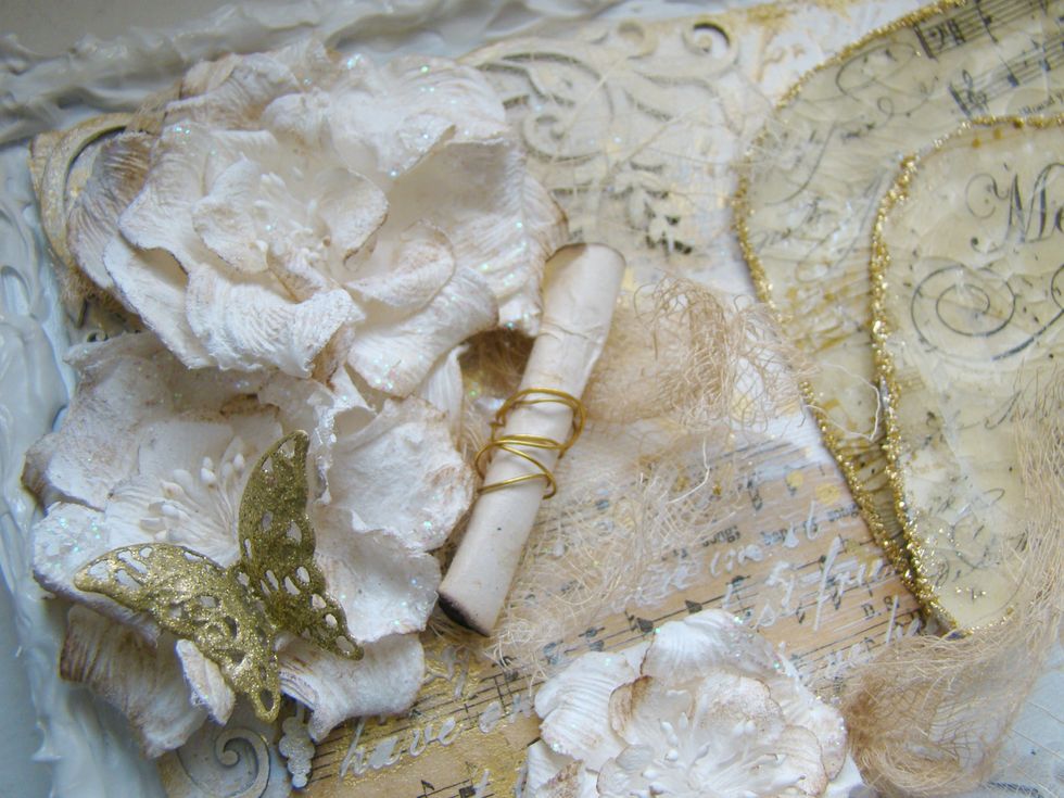 Start adding your embellishments to your canvas, I used E6000 glue for the metal embellishments and hot glue for the flowers.