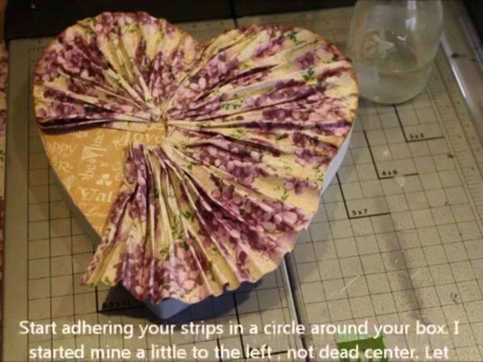 Start adhering your strips of faux fabric around your box. I started off center a bit for more interest. Just use hot glue to go all the way around.