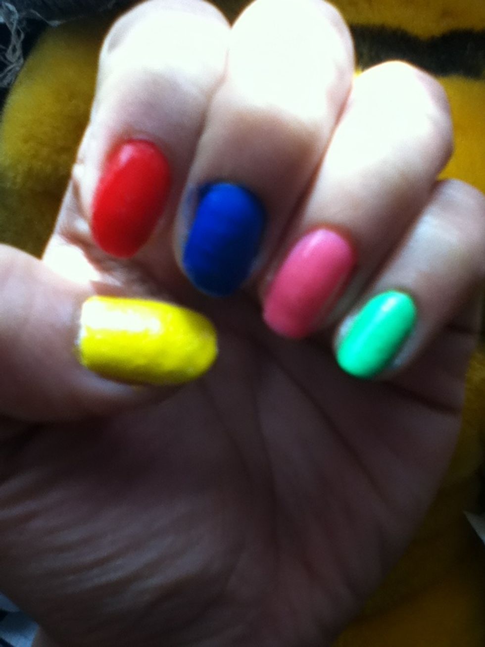Start applying a base coat on your nails then paint your thumb yellow to create the pacman and the rest of your nails red blue pink and green for the ghosts