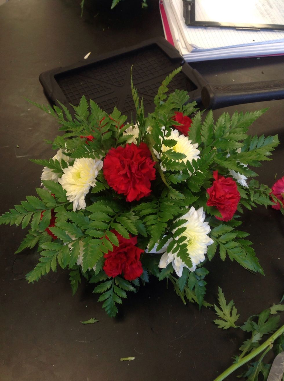 Start by adding flowers sticking strait out of the bottom. Continue to add flowers to your arrangement spreading the coors evenly