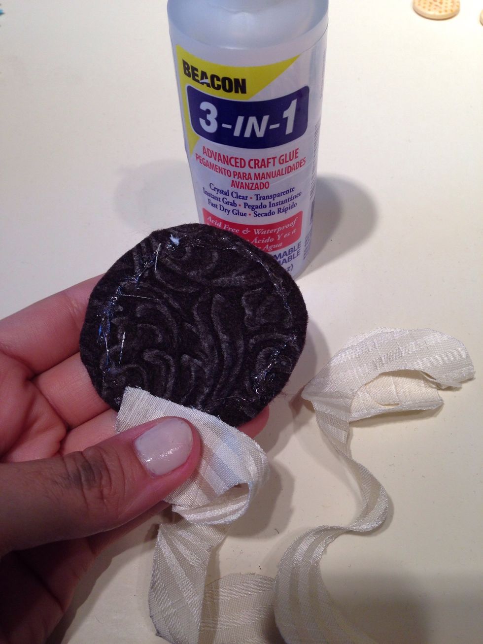 Start by adding some glue to the outside of your circle. Then only adhere the edge of the outside of your flower to the glue. Let the other side hang off the circle a little.