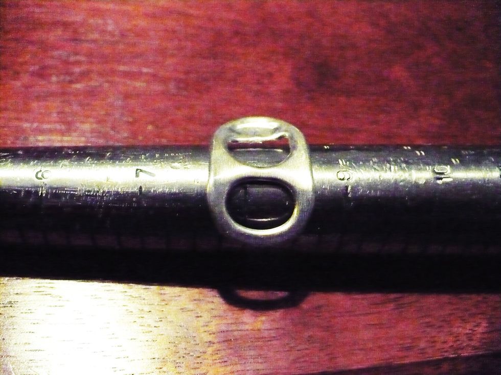 Start by bending the tab slightly. I suggest doing this with your fingers as tool mar the tab. You can bend it around the mandrel or by hand. It doesn't need to be a perfect arc, just bent a bit.