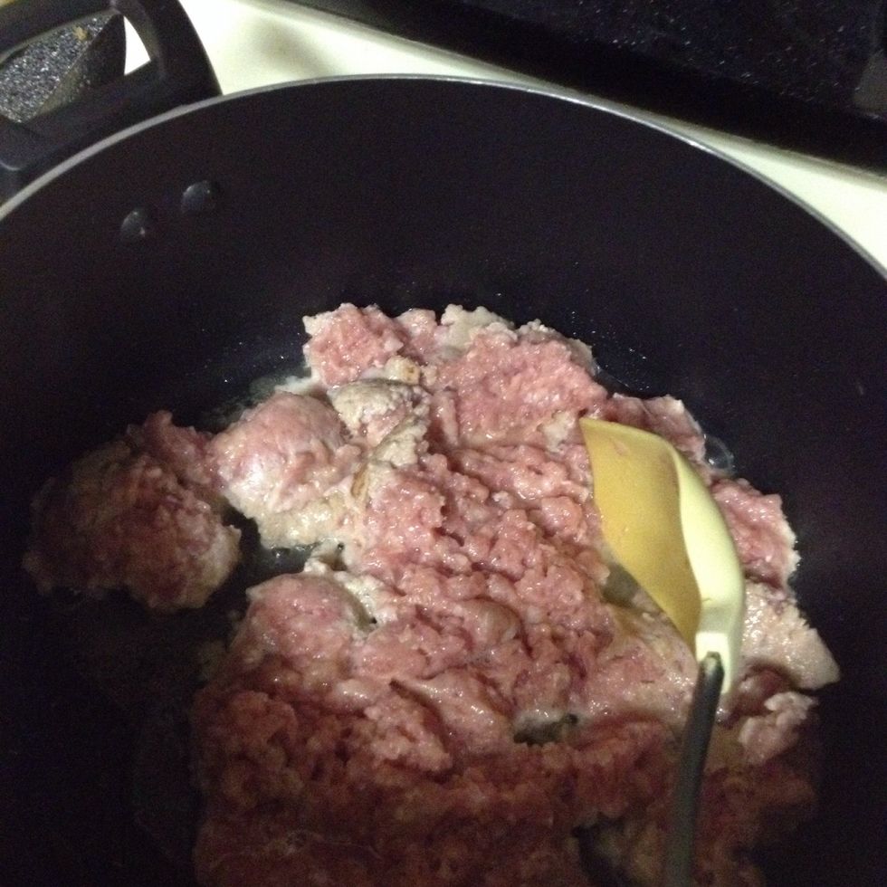 Start by browning and breaking up the sausage over medium heat in a large pot.