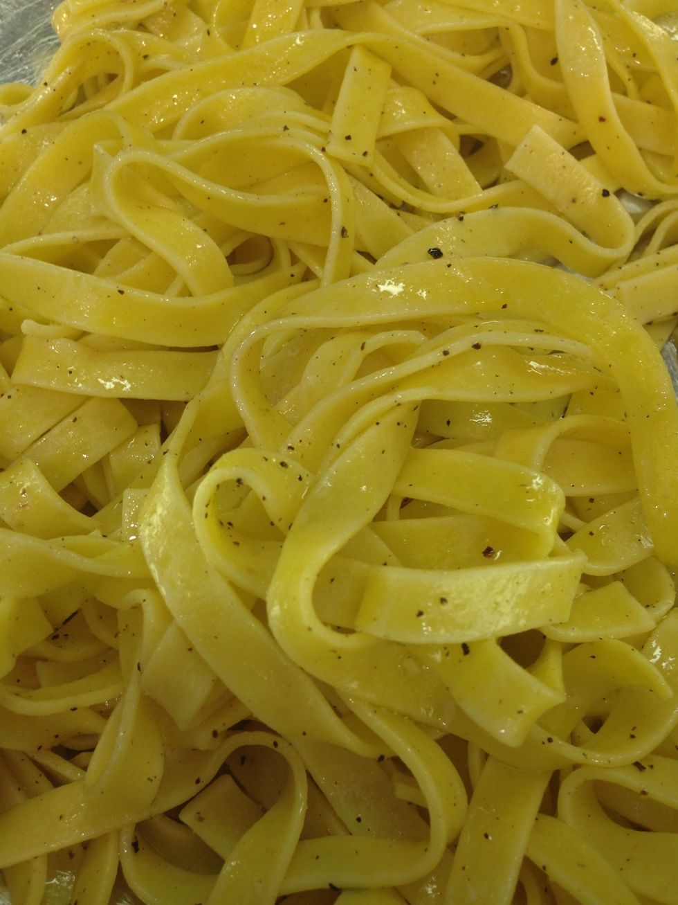 Start by cooking the pasta following the directions on the package. Toss with olive oil while warm to avoid sticking. Let cool in a bowl. Save 2 cups of pasta water for a later step in the recipe.