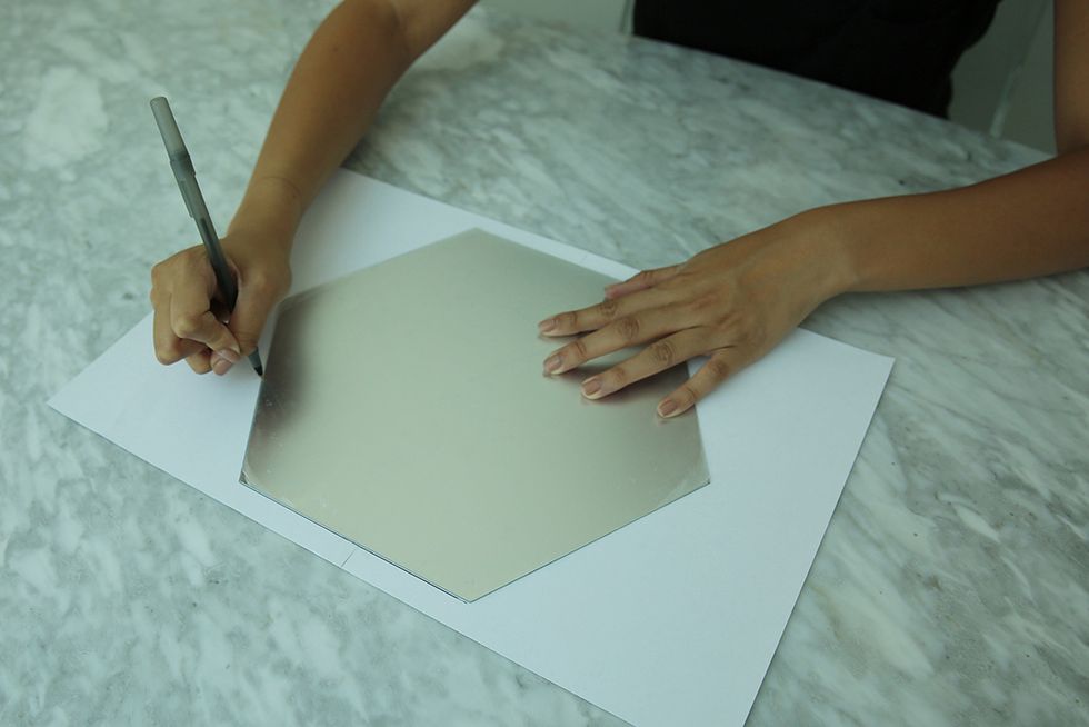 Start by creating a template from which to construct your frame. Trace the mirror on a large piece of paper. Then set your mirror aside so it doesn't get smudged.
