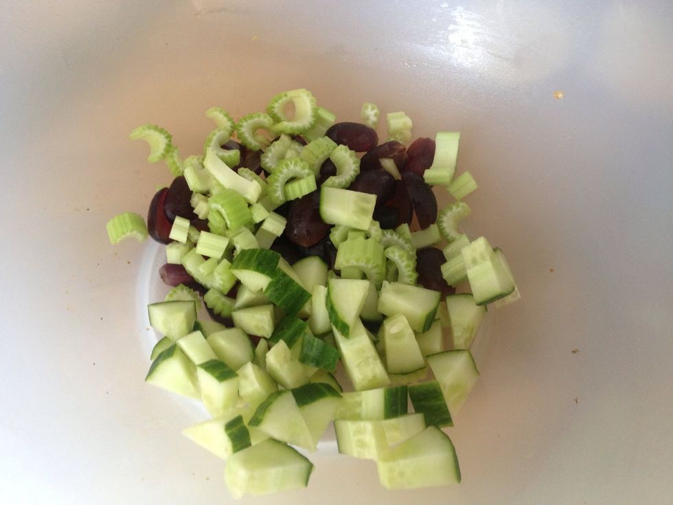 Start by halving black grapes and adding diced cucumber and celery