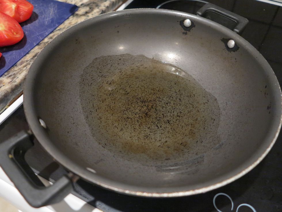 Start by heating oil in a wok on medium heat. This will prevent the chicken from being undercooked later.