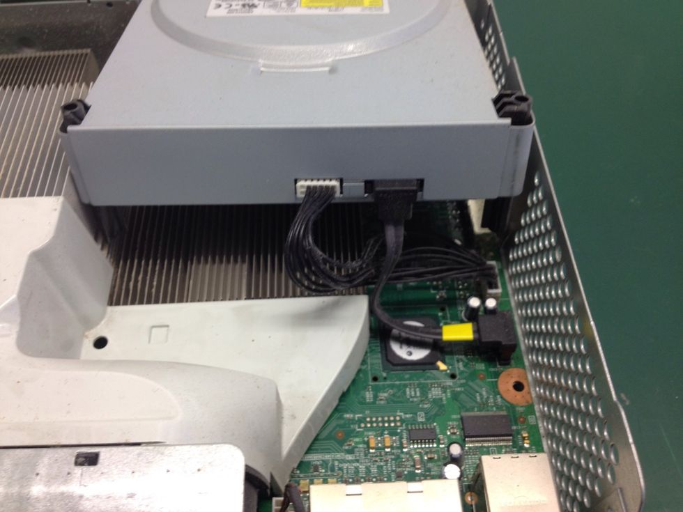 Start by lifting the DVD drive up and toward the front of the case to provide access to the cables. Pull them out and set the drive aside.