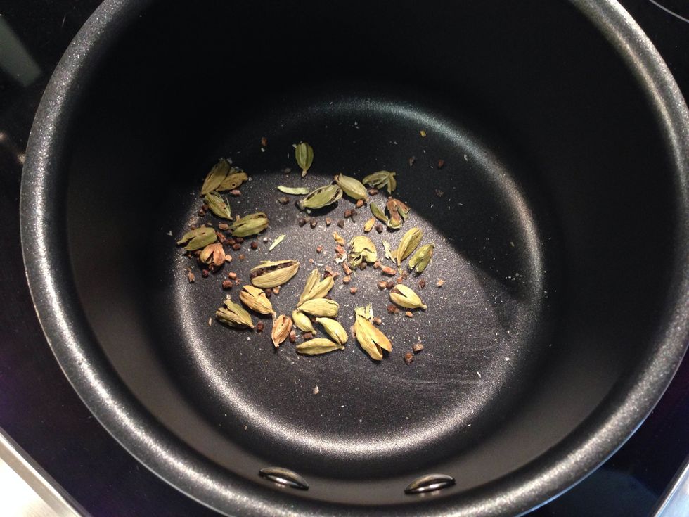 Start by making your Rooibos Simple Syrup. Lightly crush your Cardamom pods with a mortar & pestle or use the bottom of a sturdy glass. Toast them in a pan on medium for 1-3 minutes or until fragrant.