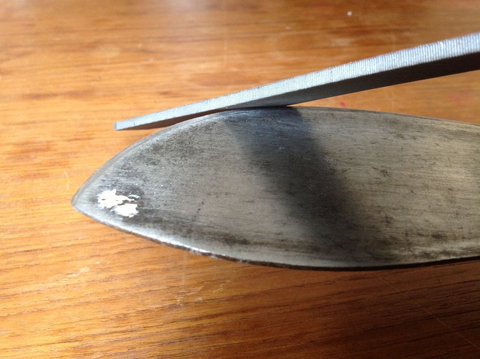 Start by positioning the cutting blade away from your body, then take the file and begin moving it over the cutting edge in a direction away from your body too. Use long, slow strokes.
