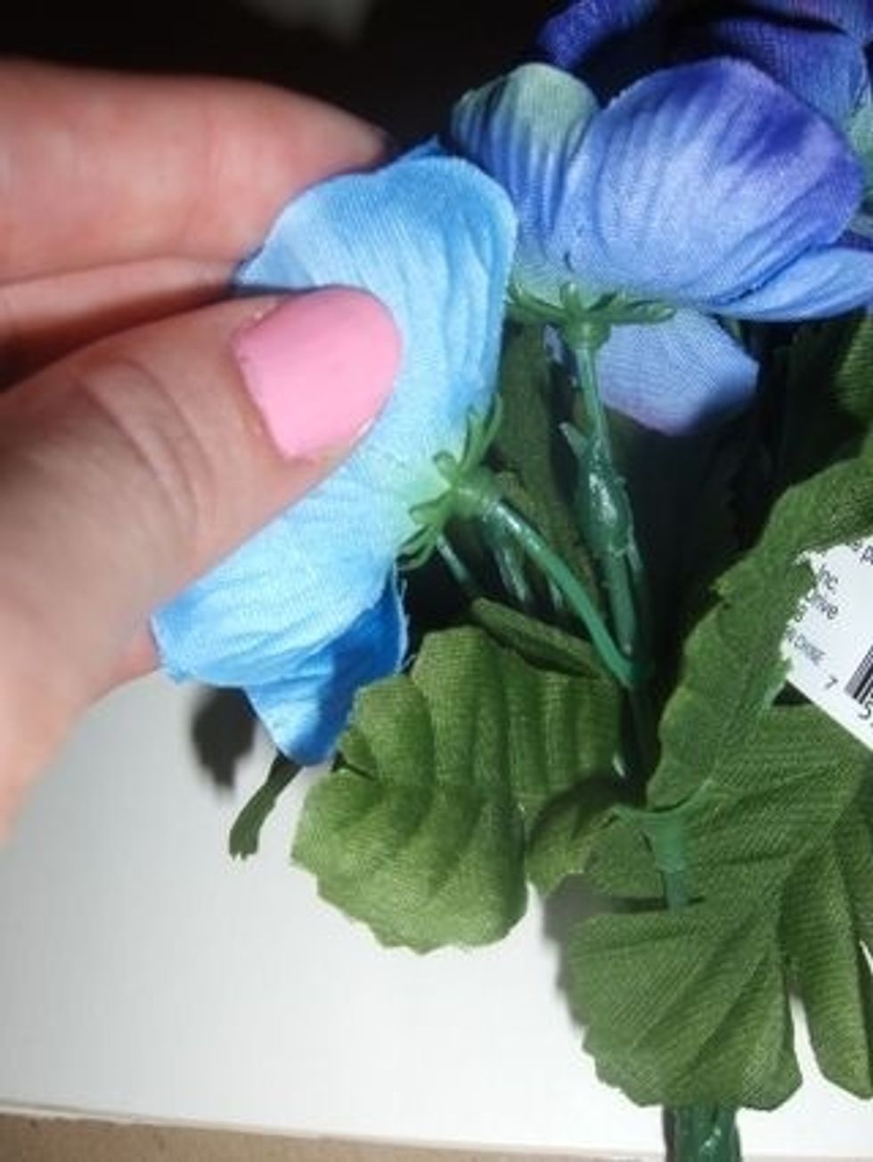 Start by removing the fake flowers by gently pulling them off