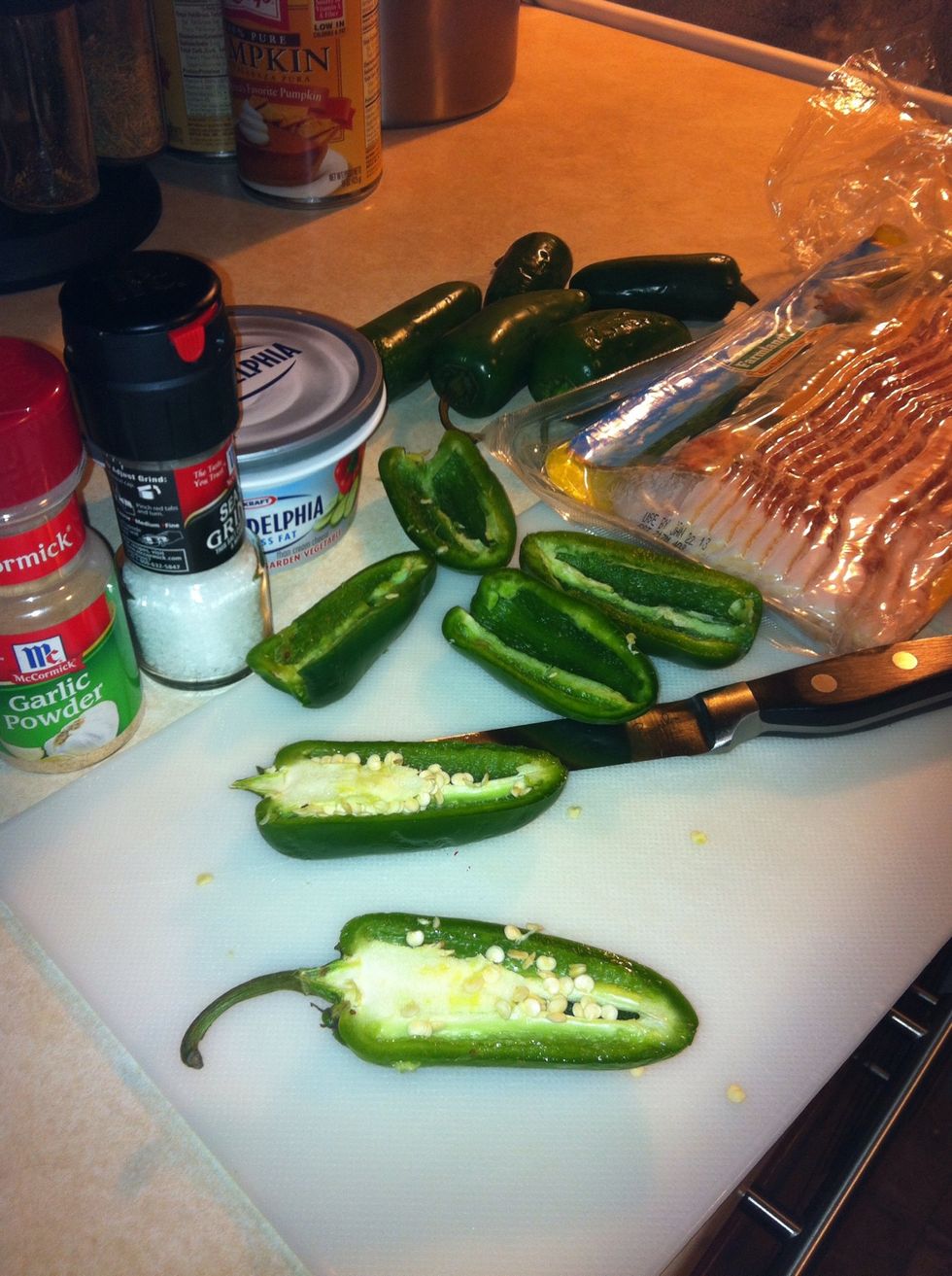 Start by setting the oven at 450 degrees then cut the jalape\u00f1os in half and cut out the insides (leave some seeds for more spice)