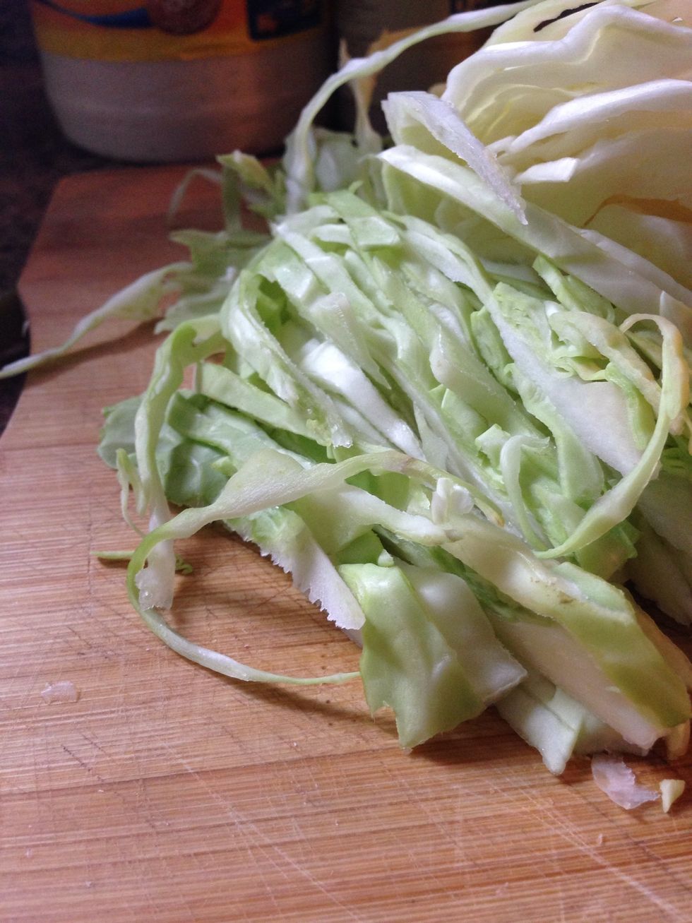 Start by slicing the cabbage thinly. You want to make sure the pieces aren't too chunky because the goal is to have a shredded effect.