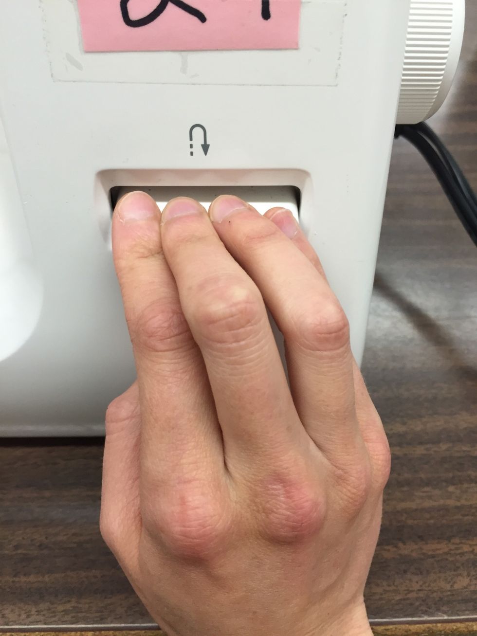 Start by stitching FORWARD 4 stitches and REVERSING 3 stitches (to reverse press and hold the reverse control down)  This is called BACKSTITCHING. Backstitching acts like a "knot."