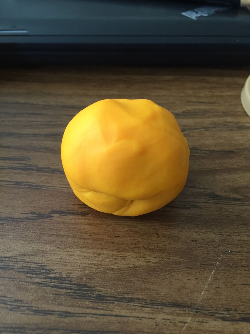 Start by taking a handful of orange play doh and rolling it into a ball.