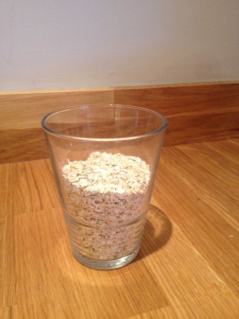 Start by taking around 50g of porridge which is about two small handfuls or half of this glass. Add this to a pan (or a bowl if you prefer to use the microwave)