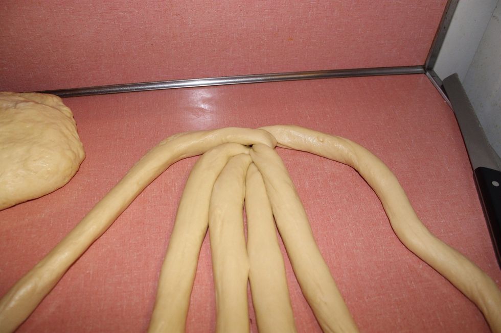 Start by taking the left outermost strand and cross it all the way to the right, take the right outermost one and cross it all the way to the left