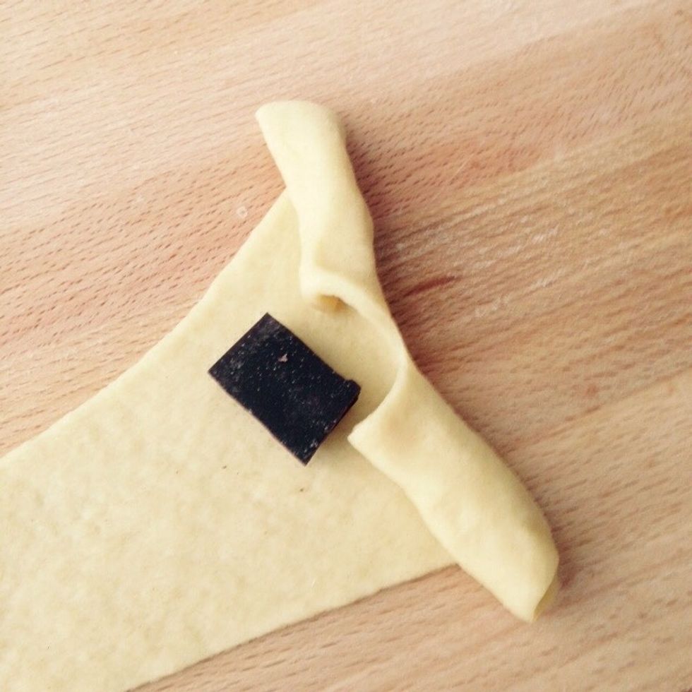 Start by the side with the cut. Rolling the strip of dough, spread the cut parts and roll all the way to the tip of the triangle.