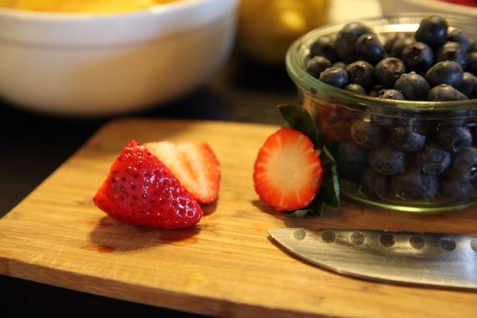 Start by topping and halving strawberries.