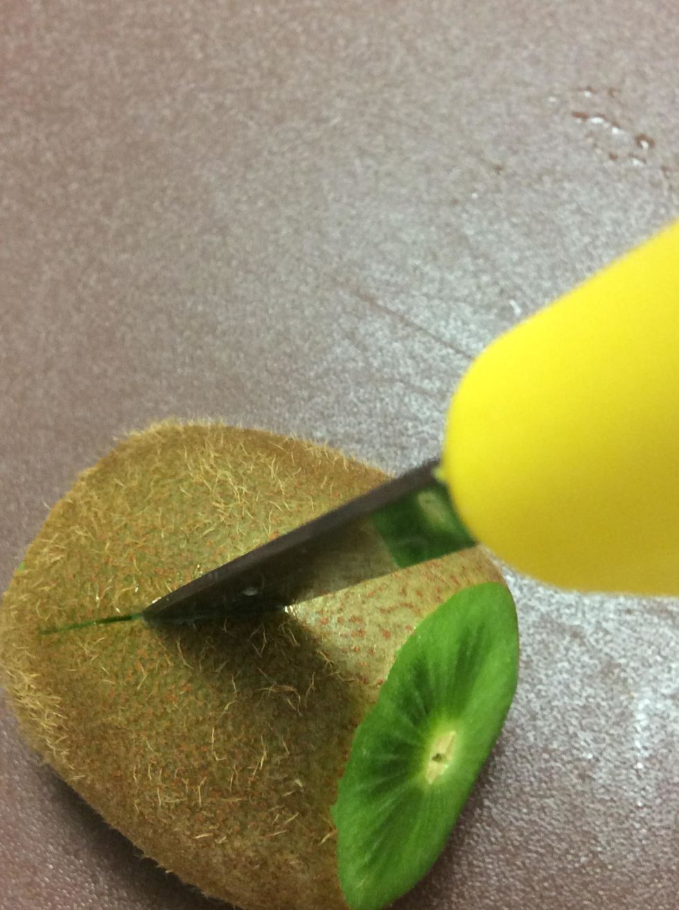 Start cutting into the kiwi in a zig-zag way. (in the middle)