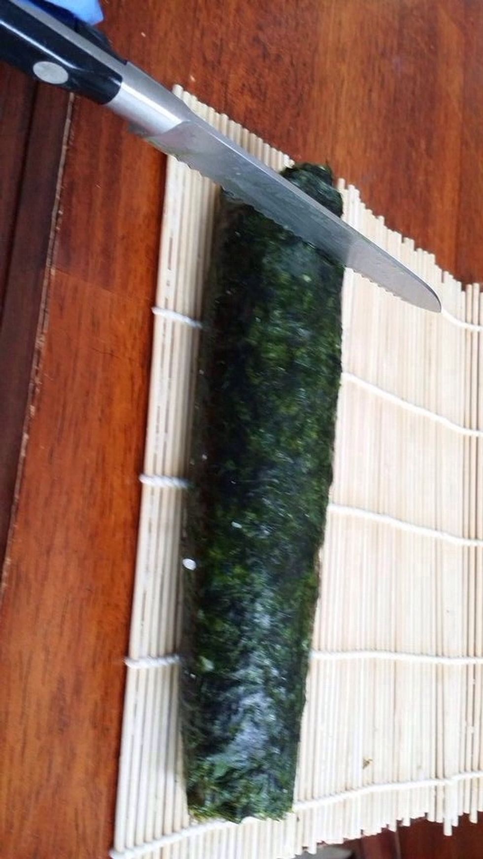 Start cutting the sushi roll into 6 equal pieces, each about 1/2 an inch long.