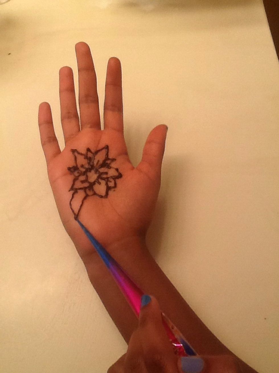 Start drawing a leaf coming out of any two petals.