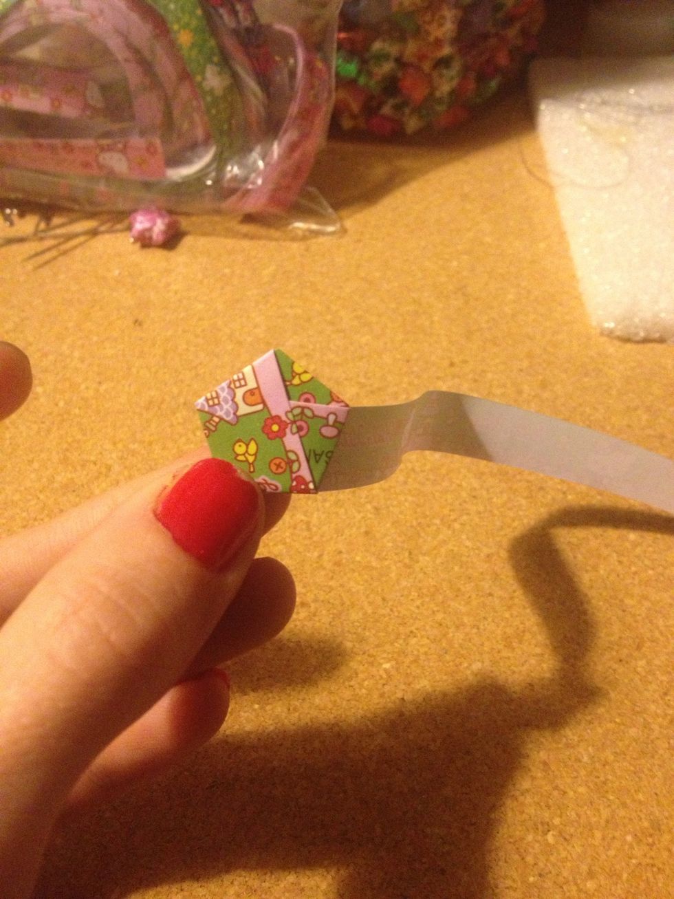 Start folding the paper around the hexagon shape. It will naturally fold in the direction it needs to go. Pinch the fold just a little bit.