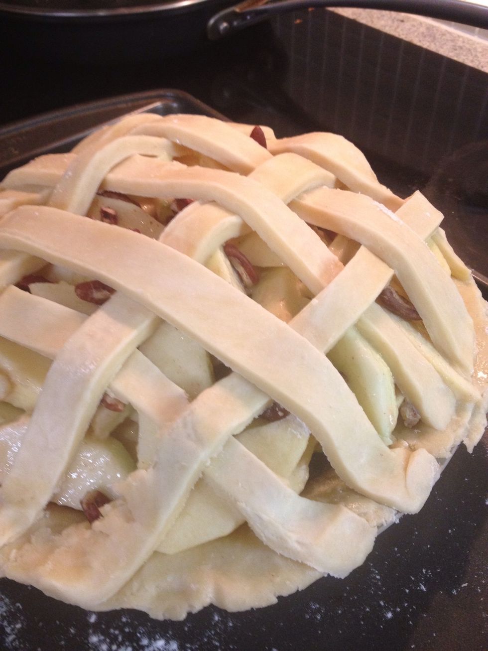 Start from the middle and lay down a couple longer strips verically, then add a couple horizontally and weave the pieces over then under in an alternating fashion until your lattice crust is finished.