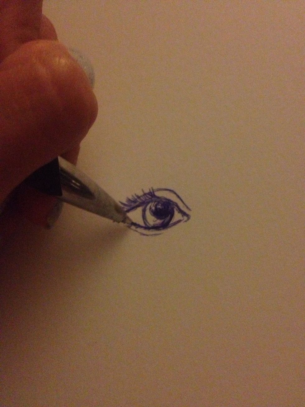 Start getting more deliberate with your pen by making the lines of the lashes darker. Color the pupil, but leave a bit of it uncolored. This acts as a highlight on the pupil and will add contrast.