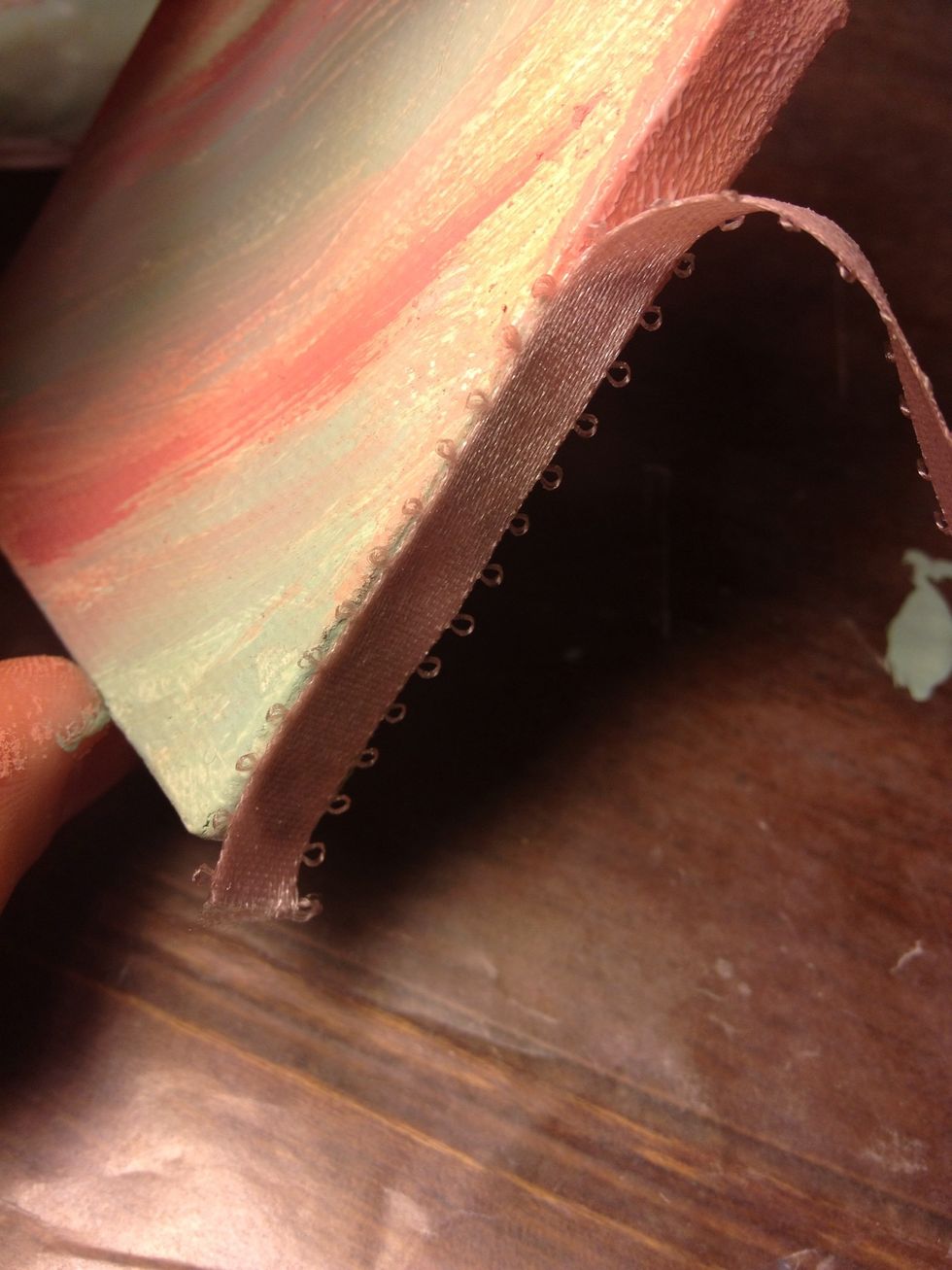 Start gluing the ribbon down around the edges of your piece leaving a bit extra at the starting corner.I used fabric mod podge, but I bet regular would be fine.