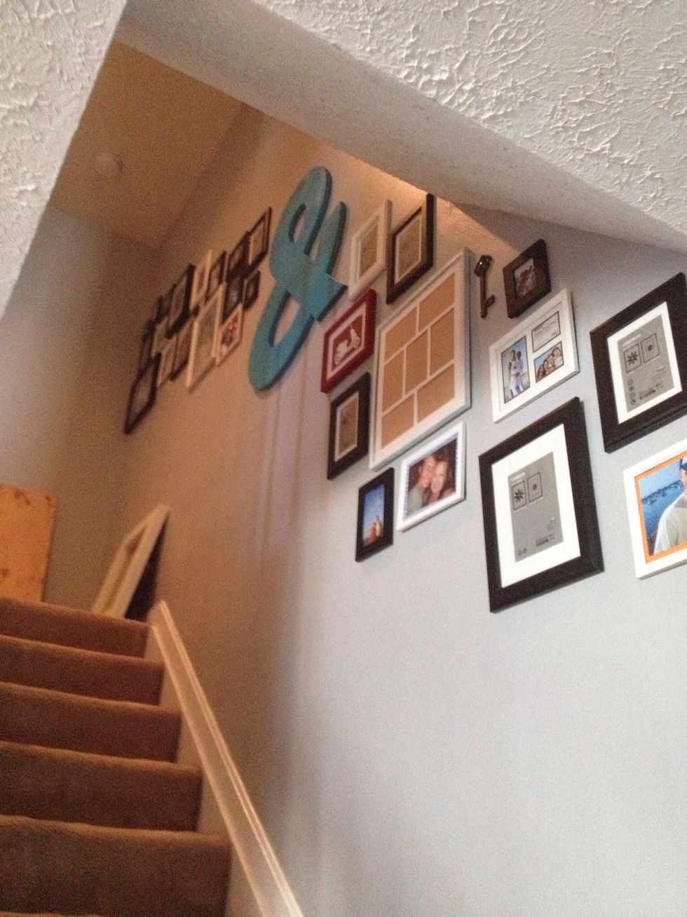 Start hanging your frames! All you need to do is hammer a nail through the mark you made and then pull the paper off as you put your frame up! Don't worry about artwork just yet, get the frames up.