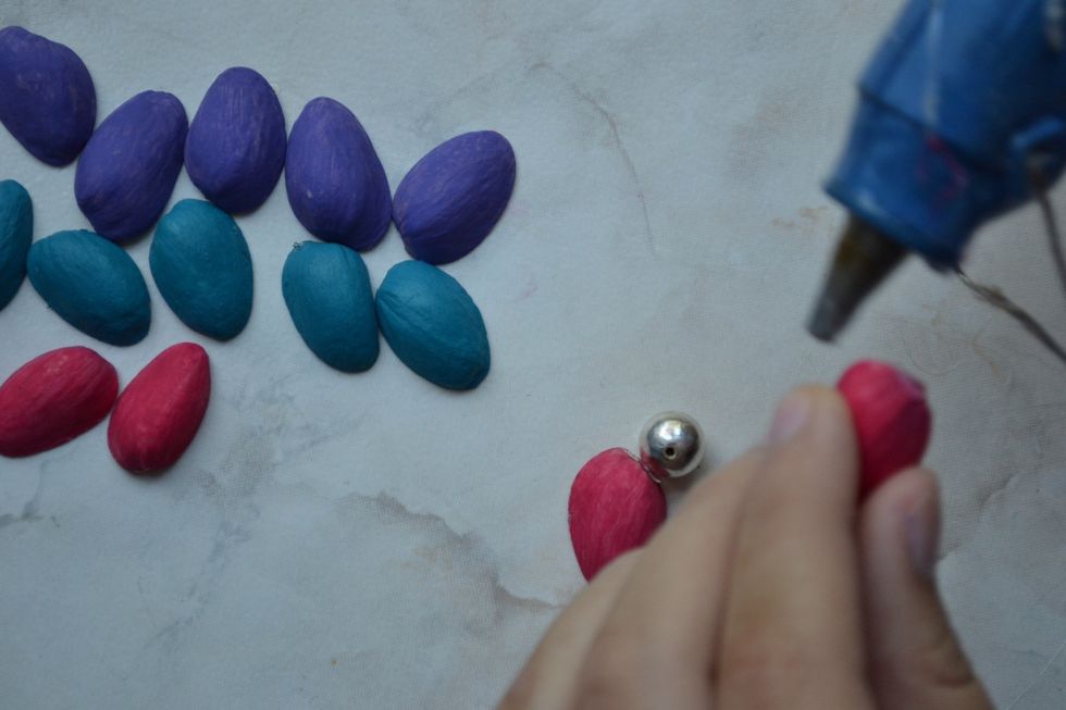 Start hot glueing the shells with the beads