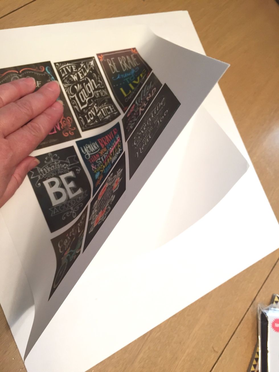 start in a corner of the white chipboard and line up the corner of the page with it. DO THIS CAREFULLY! the adhesive is STRONG! once you have stuck it down, it is not easy to remove.