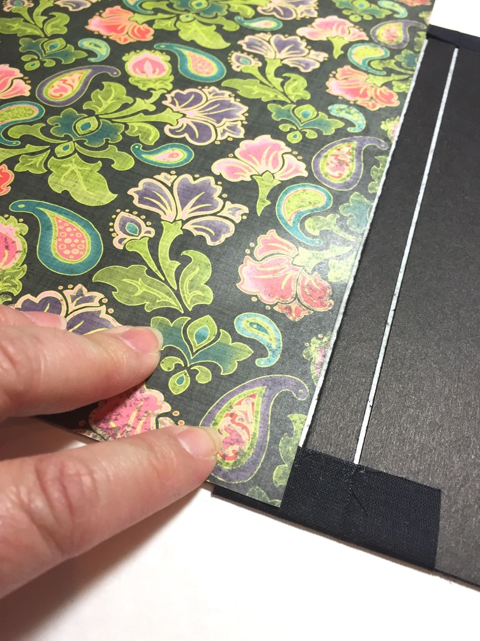 start in corner again and smooth paper down to inside of front cover. trim using scissors or an exacto knife and metal ruler.