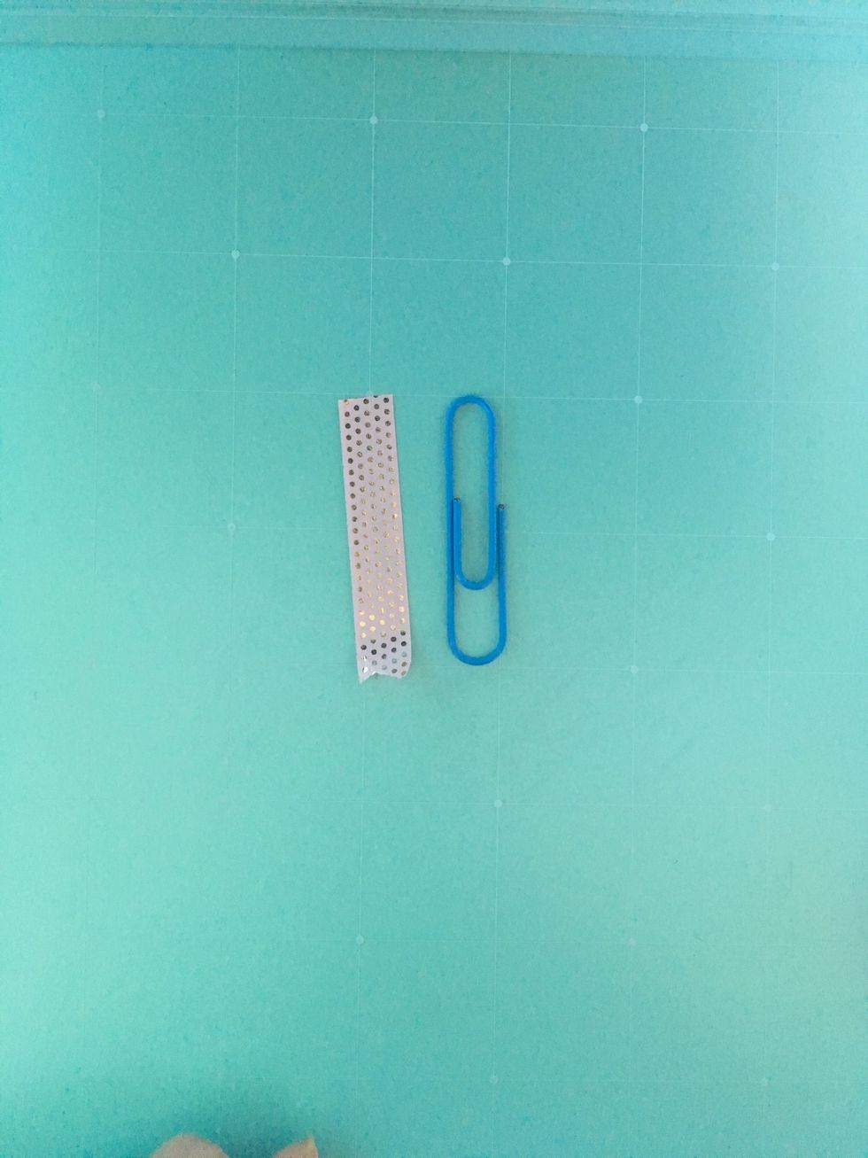 Start out with a paperclip and a piece of tape about an inch long.