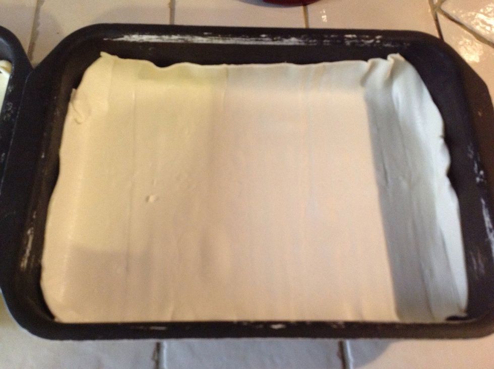 Start oven at 175 degrees celcius. Line the bottom of a dish with baking paper or greese with some oil. Roll the pizza dough and place it thinly on the base of the dish.