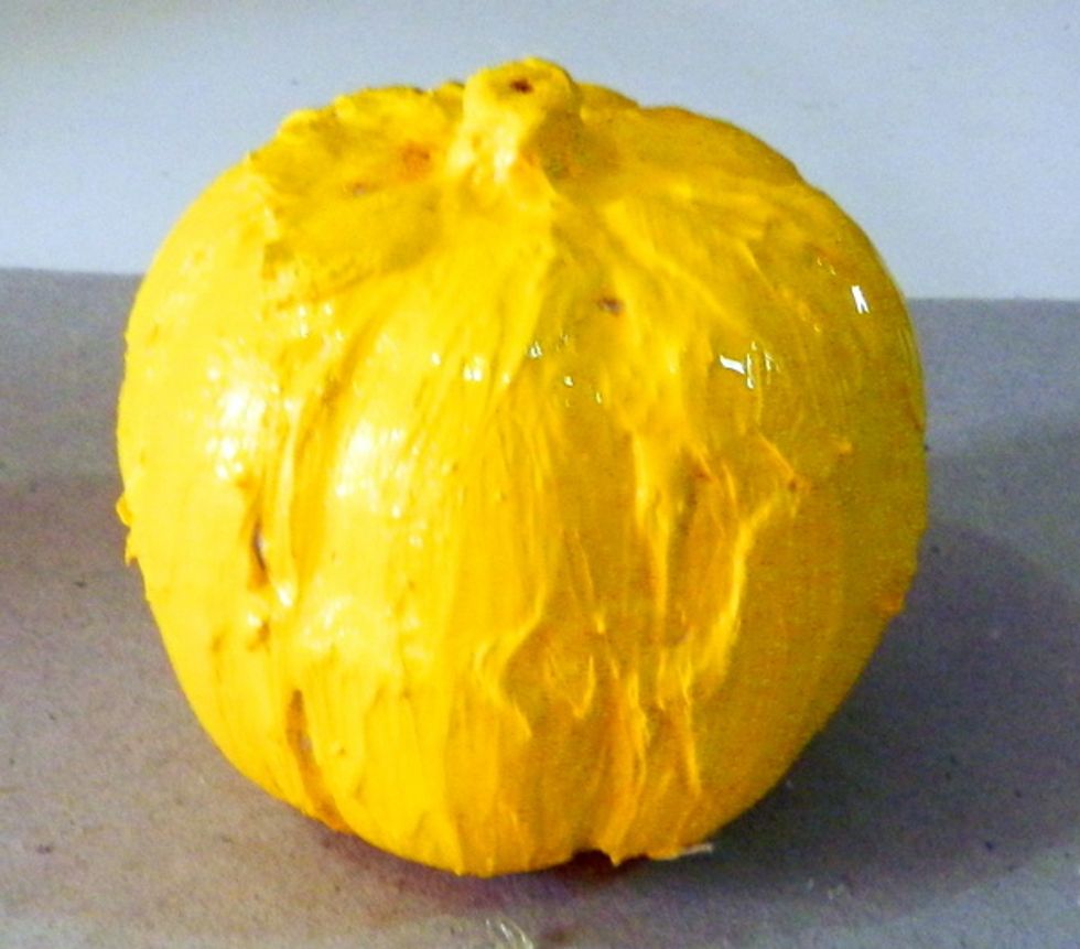 Start painting your pumpkin with yelow-orange.
