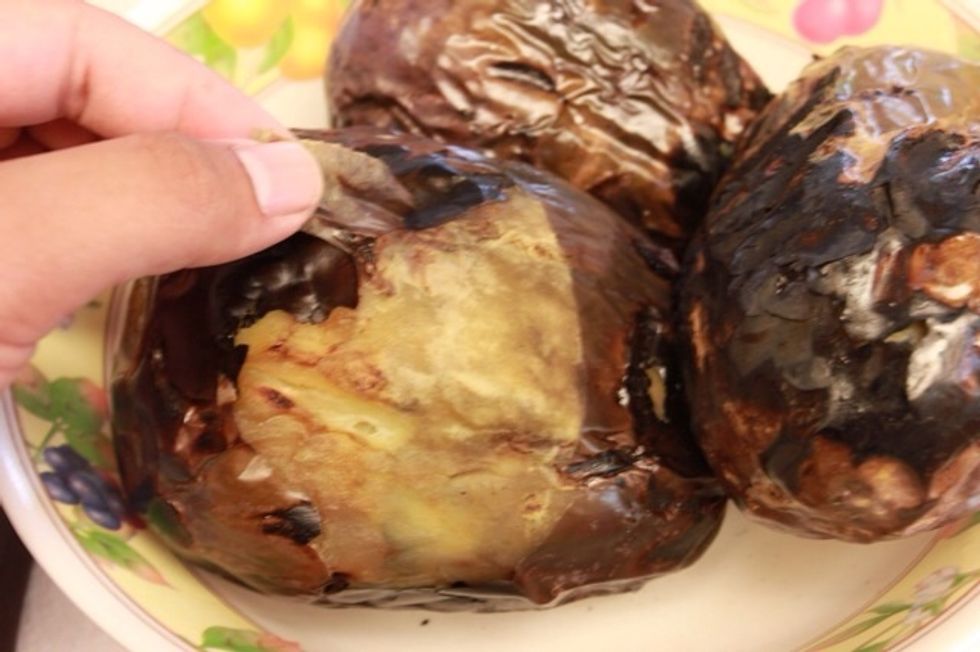 Start peeling the skin off of the eggplants. Try to get all of it if you can.