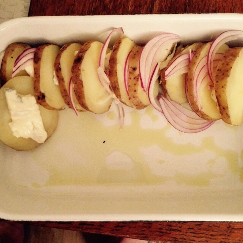 Start placing the potatoes, gorgonzola and red onion in layers sideways.
