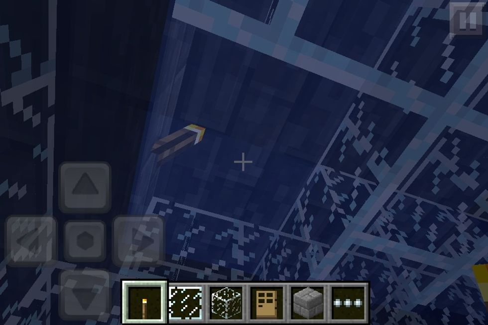 Start placing whatever blocks you want from the ceiling down and place a torch as soon as you can. The blocks when broken are air instead of water, which is good :).