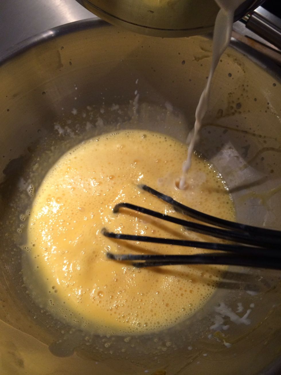 Start pouring the boiling cream bit by bit while whisking.