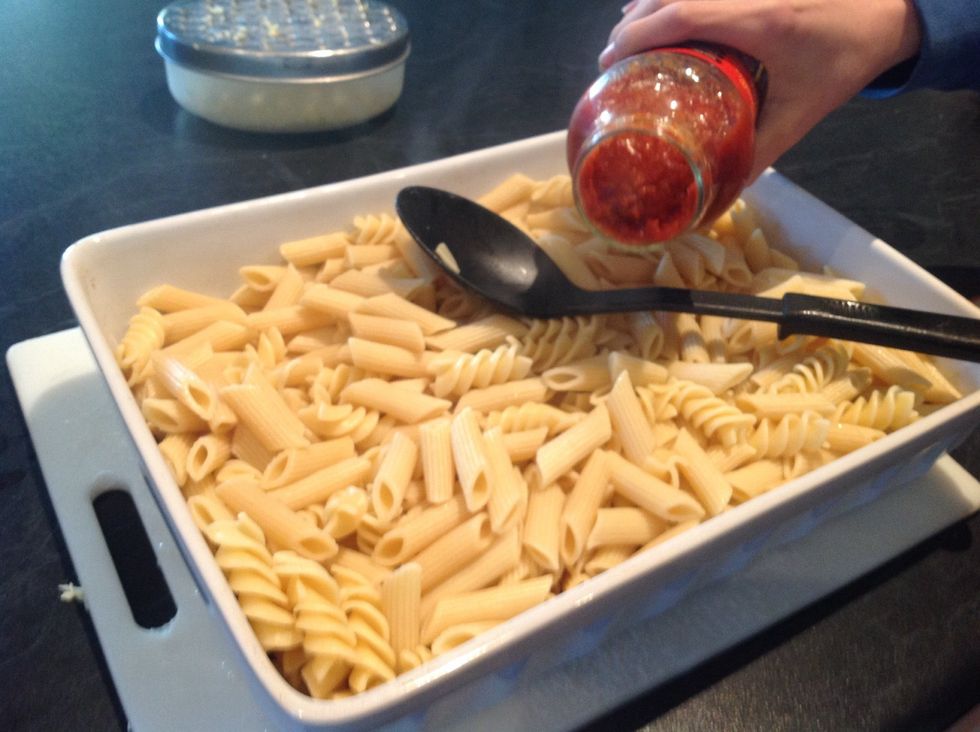 Start putting in the tomato sauce and mix it through with the macaroni.