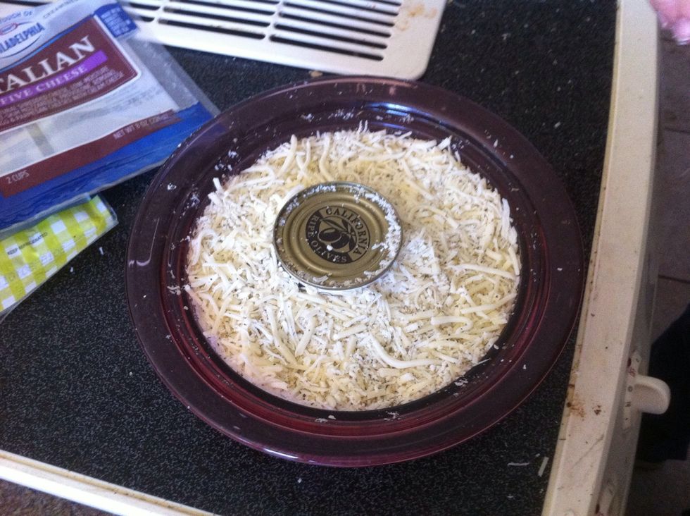 Start putting the rest of the cheese mixture around the can.  When all the cheese is in the dish push down on the cheese and clean any extra cheese off the top sides \u27a1