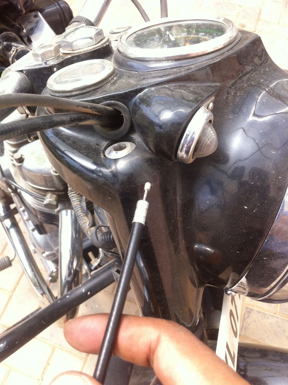 Start routing the cable through the headlamp casing hole.