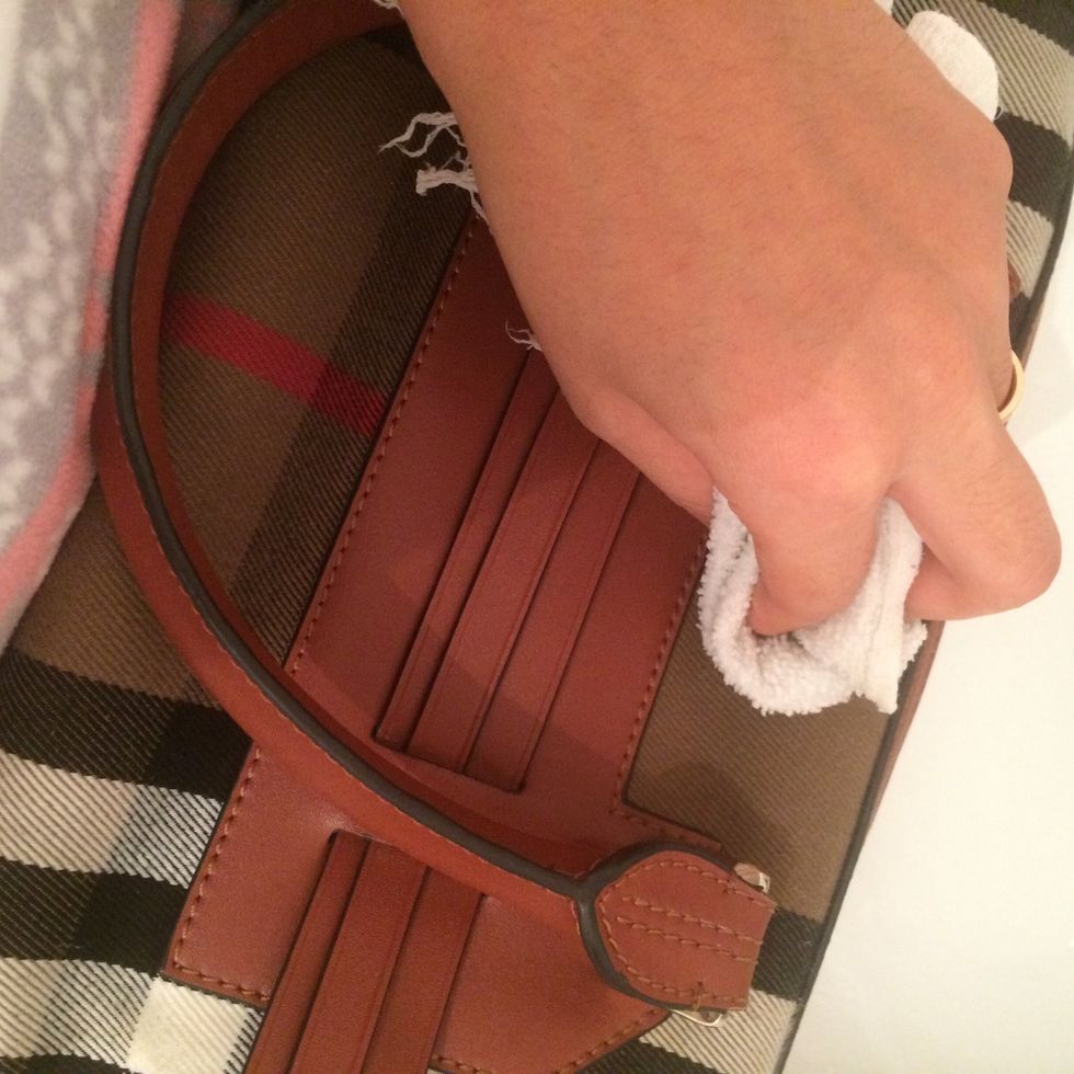 Start rubbing the fabric of the bag firmly but gently.Focus on the parts that has spots or you know have gotten darker.You will see the dirt on your rag, and you will notice the fabric looking cleaner