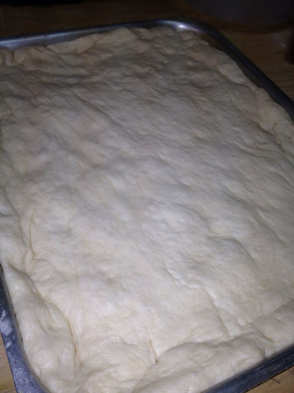 Start spreading the dough in the pan using your hands until it covers all sides.