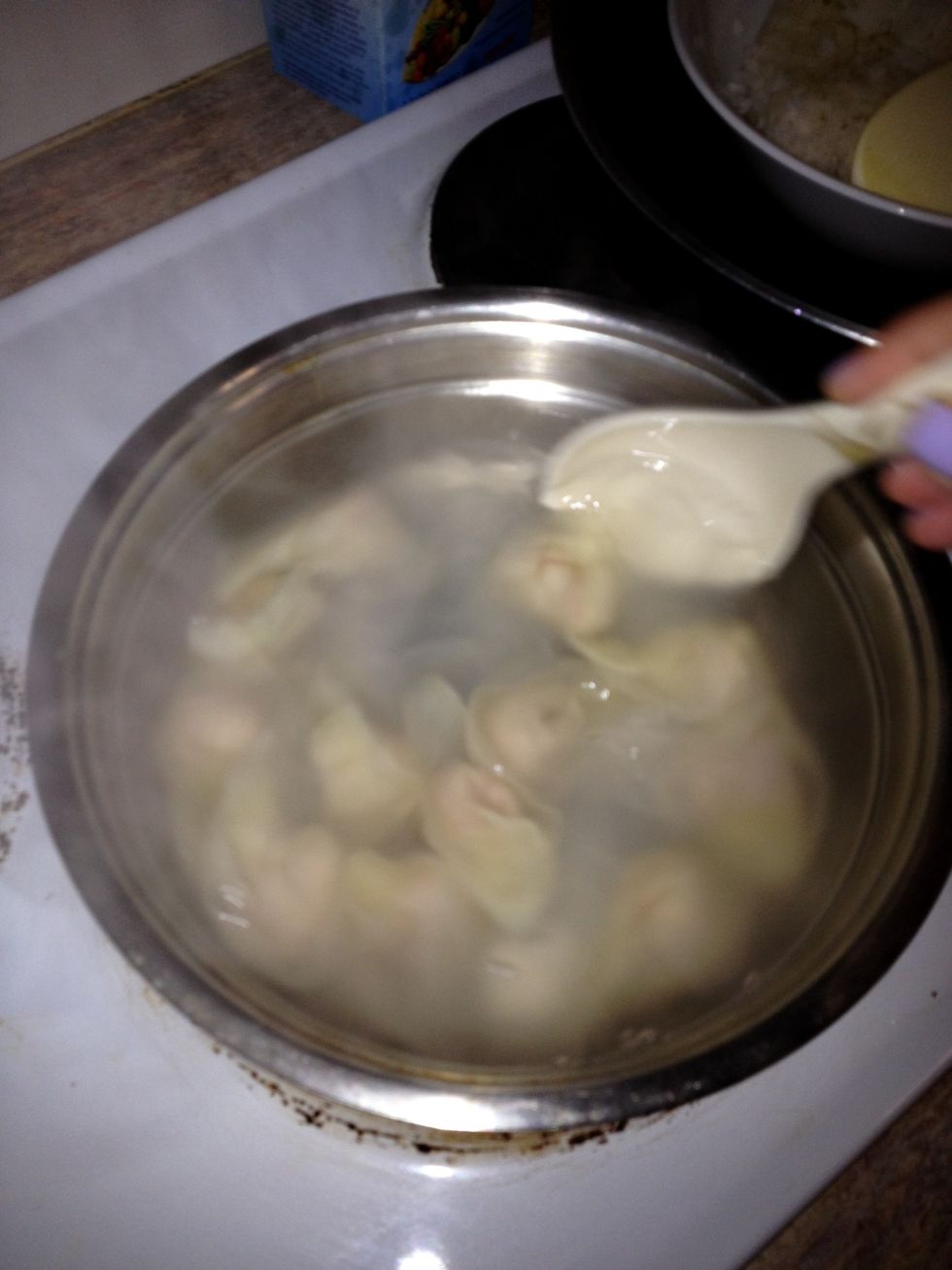 Start stirring the water with a large spoon and add one by one the wontons, max 10-15. Keep stirring the wontons, don't let them stick to the bottom. Cook to 2 mins.